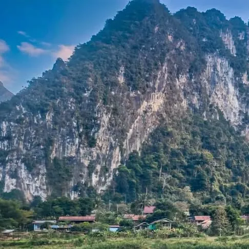 Limestone mountain rising above a village in northern Laos