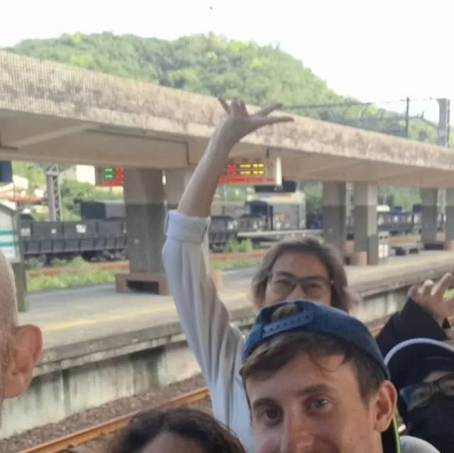 Harry and friends waving on a station platform in the mountains