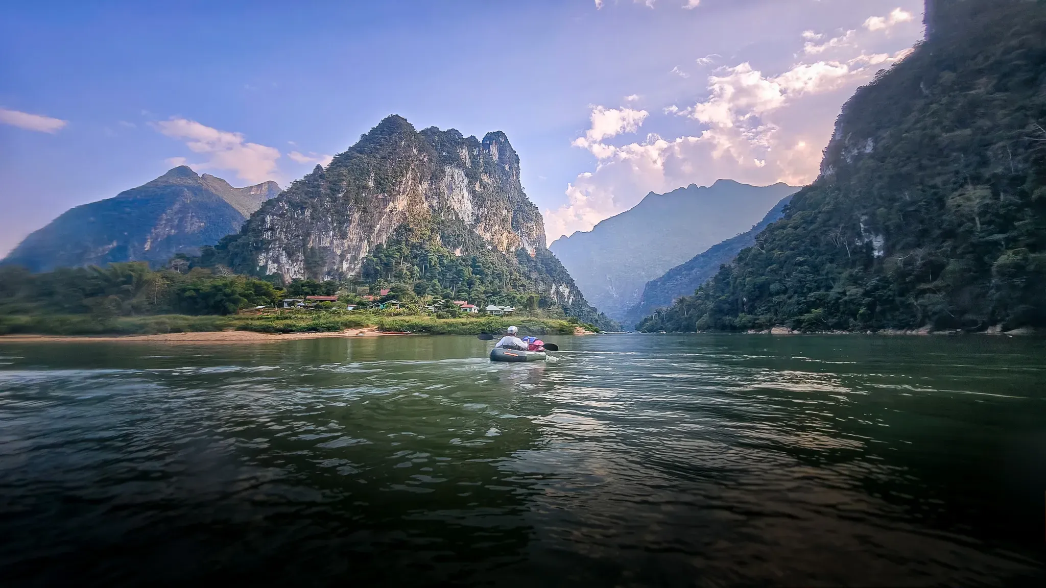 Packrafts on the wide Nam Ou river beneath karst mountains near Muang Ngoi