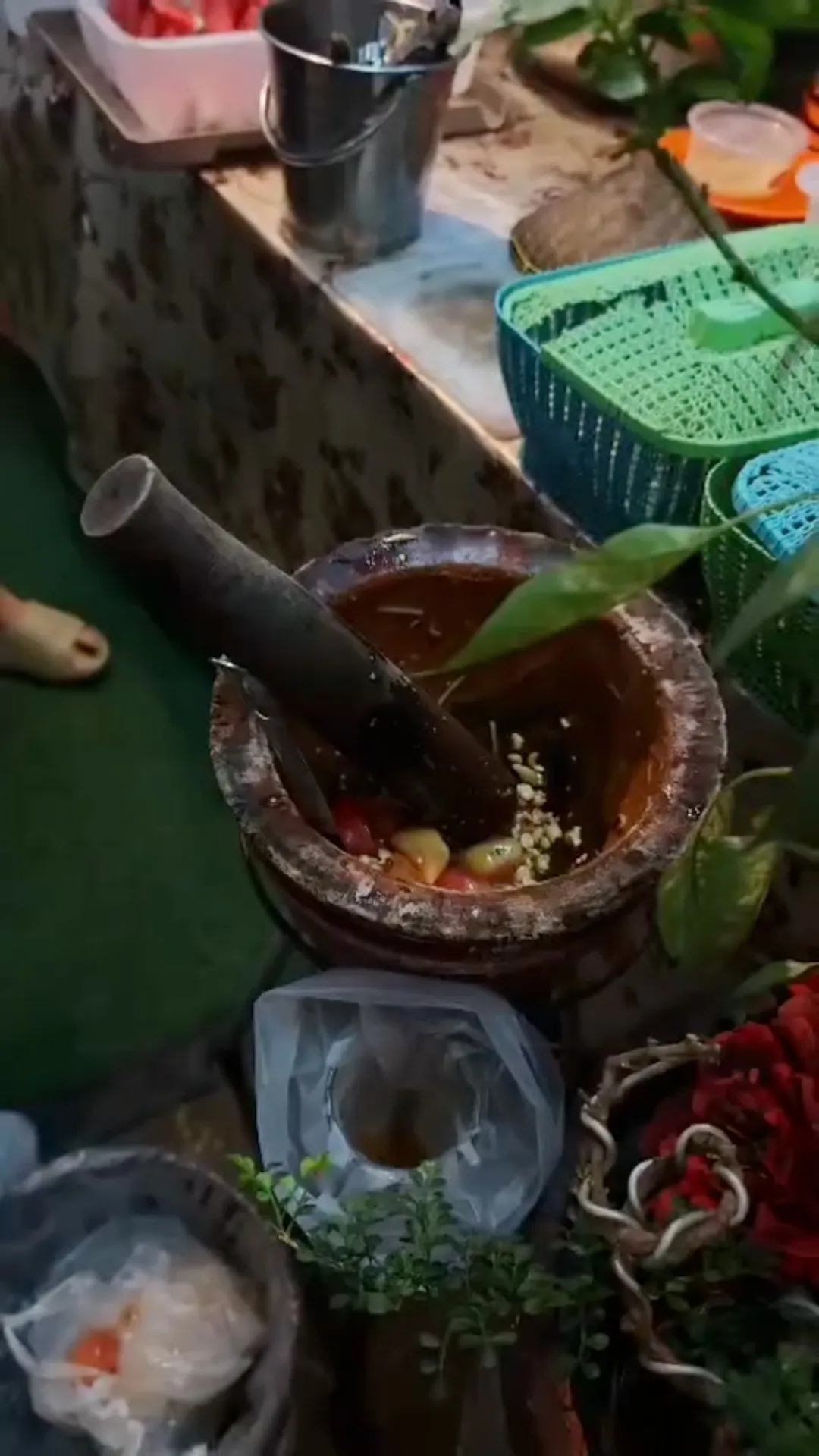 Pounding Som Tam in a clay mortar