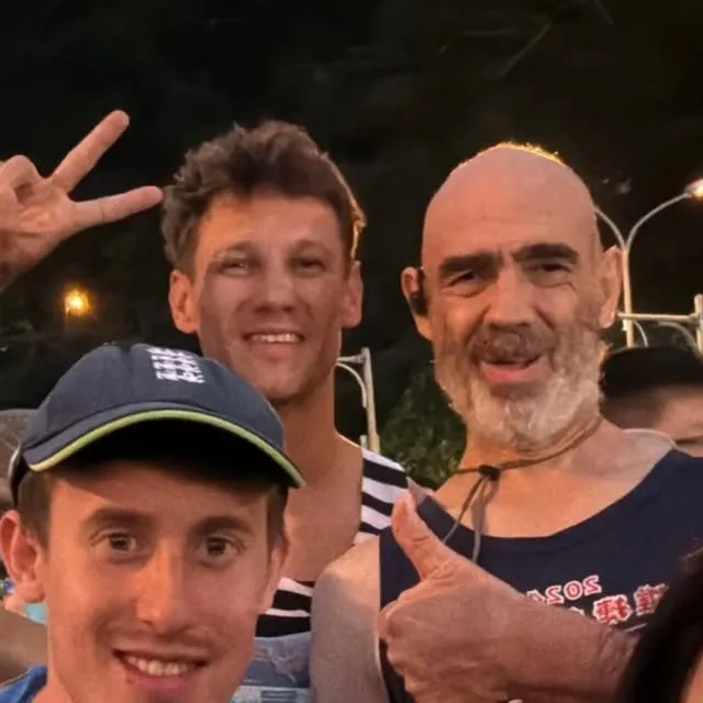 Harry and friends grinning at night after the race
